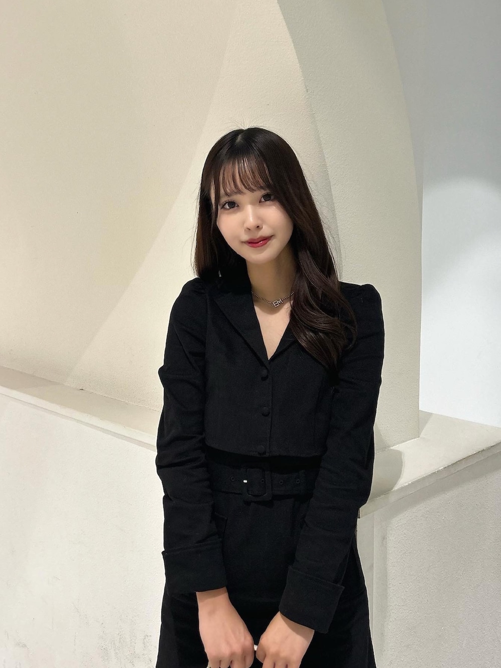 ブラック系のブーツ、ベージュ系のショルダーバッグ、ブラック系のワンピースを着用したレディースの冬コーディネートの2枚目の写真