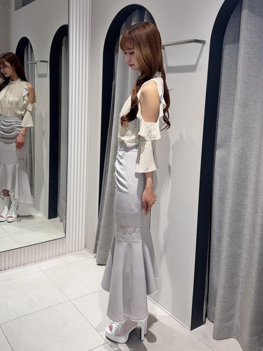 グレー系のスカート、イエロー系のシャツ/ブラウス、ホワイト系のブーツを着用したレディースの春コーディネートの3枚目の写真