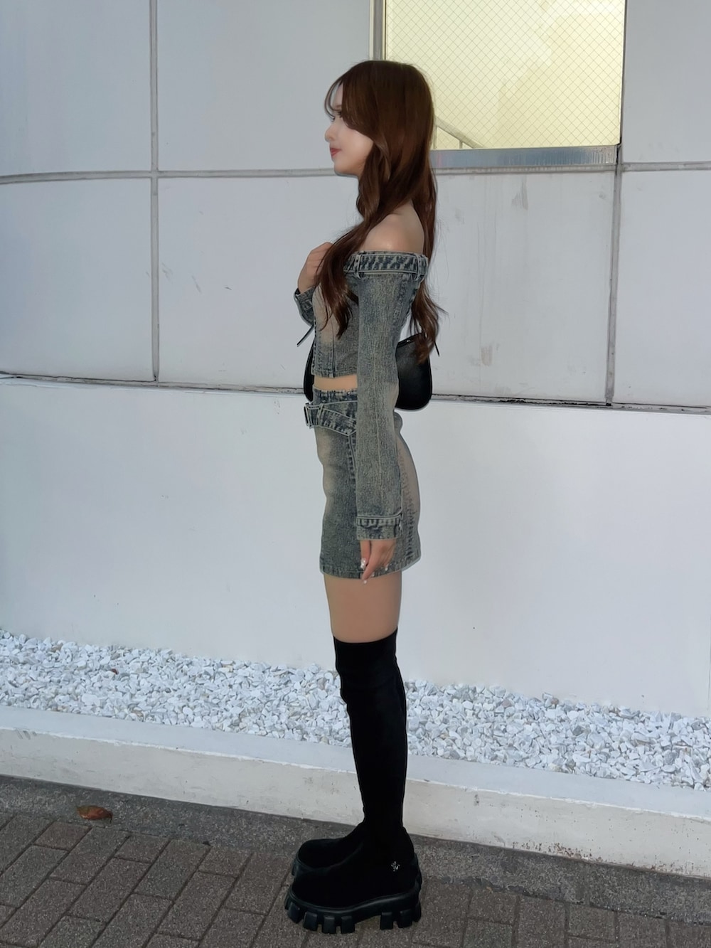 ブルー系のその他トップス、ブルー系のデニムスカート、ブラック系のブーツを着用したレディースの秋コーディネートの3枚目の写真