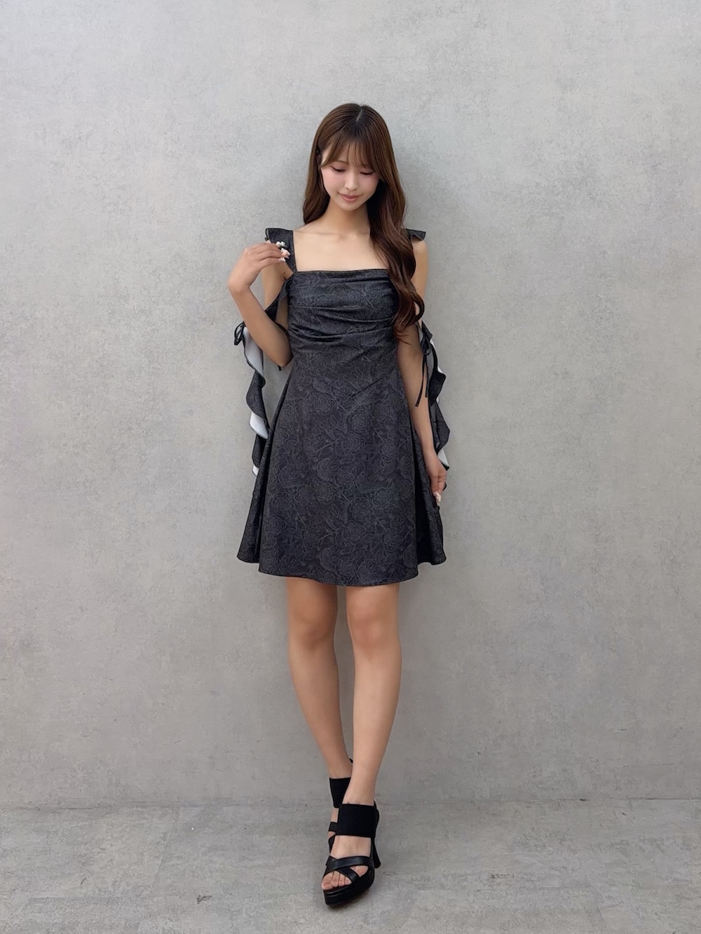 ブラック系のワンピース、ブラック系のサンダルを着用したレディースの夏コーディネートの2枚目の写真
