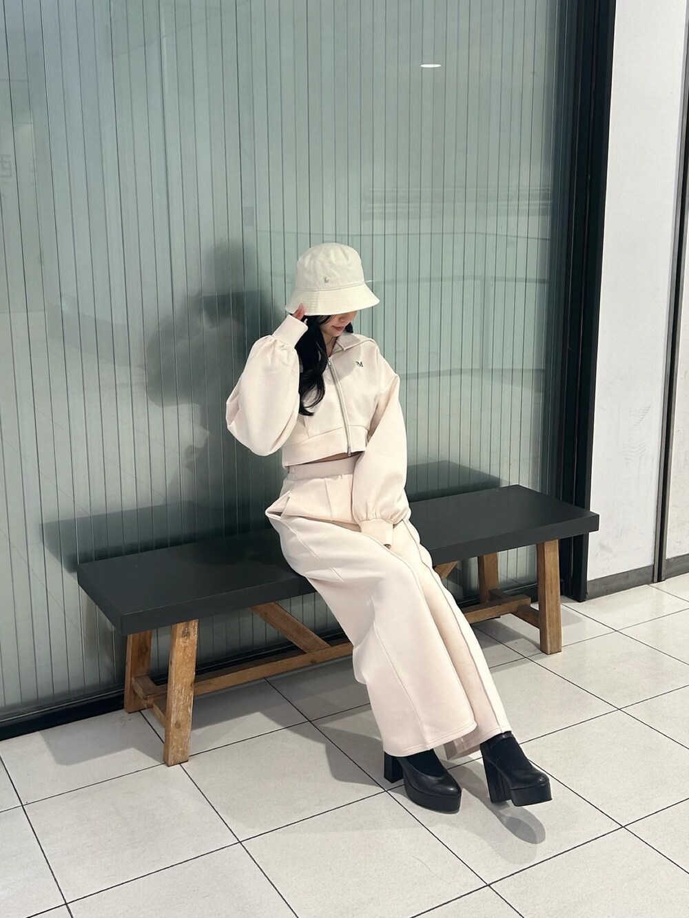 ホワイト系のパーカー、ホワイト系のその他パンツ、ブラック系のパンプスを着用したレディースの冬コーディネートの3枚目の写真