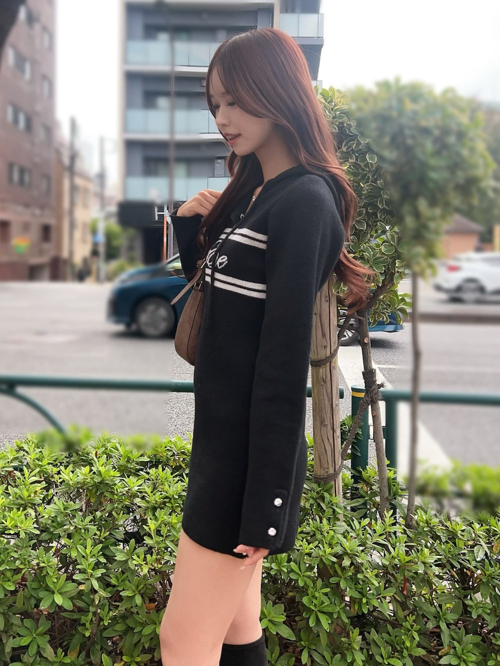 ブラック系のブーツ、ブラック系のワンピース、ブラウン系のショルダーバッグを着用したレディースの秋コーディネートの6枚目の写真