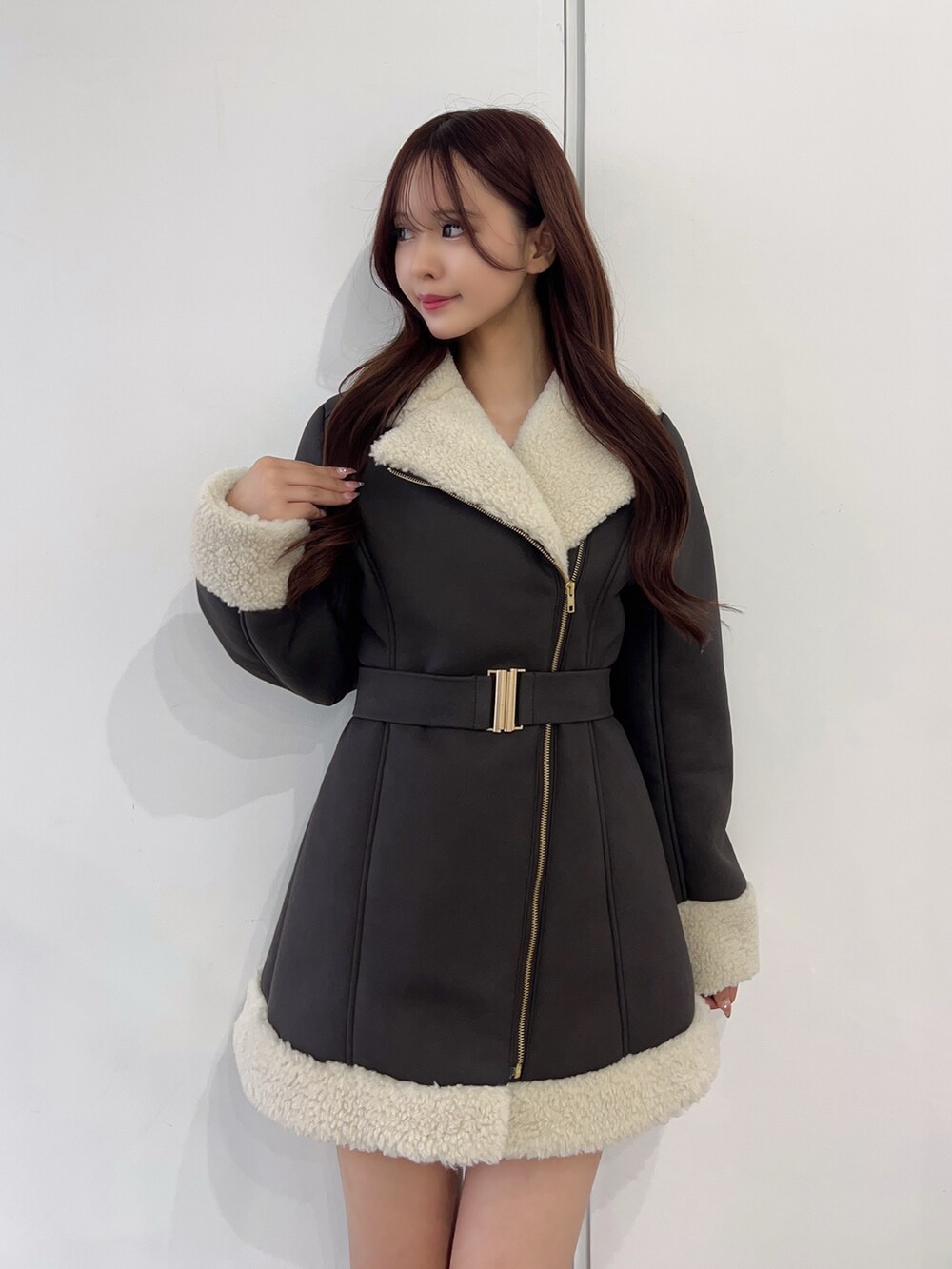 ブラウン系のムートンコート、ブラック系のブーツを着用したレディースの冬コーディネートの5枚目の写真