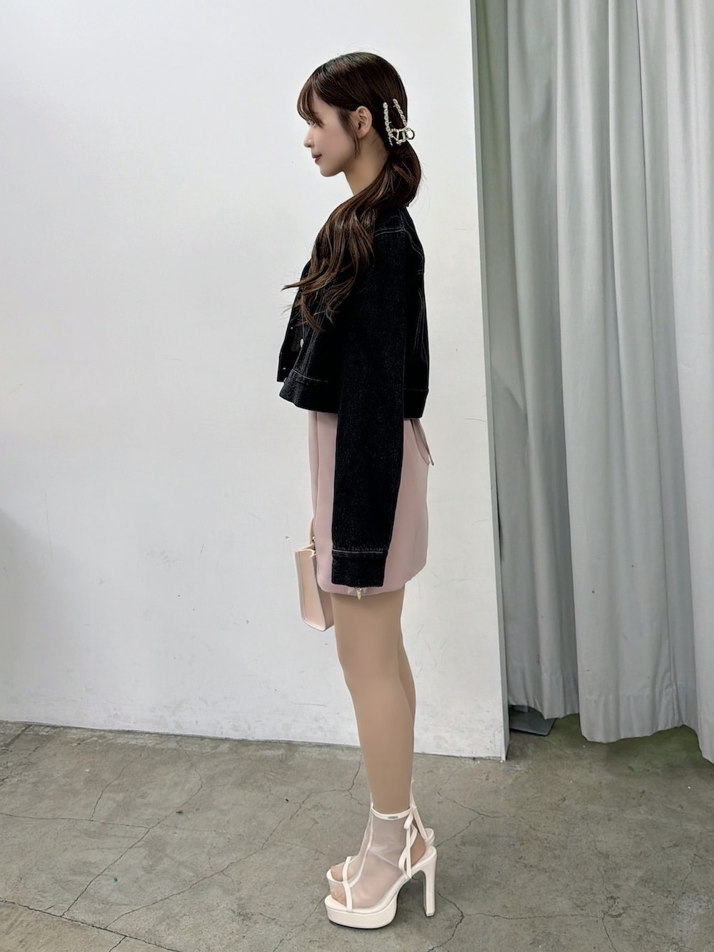 ピンク系のワンピース、ブラック系のデニムジャケット、ホワイト系のサンダルを着用したレディースの春コーディネートの3枚目の写真