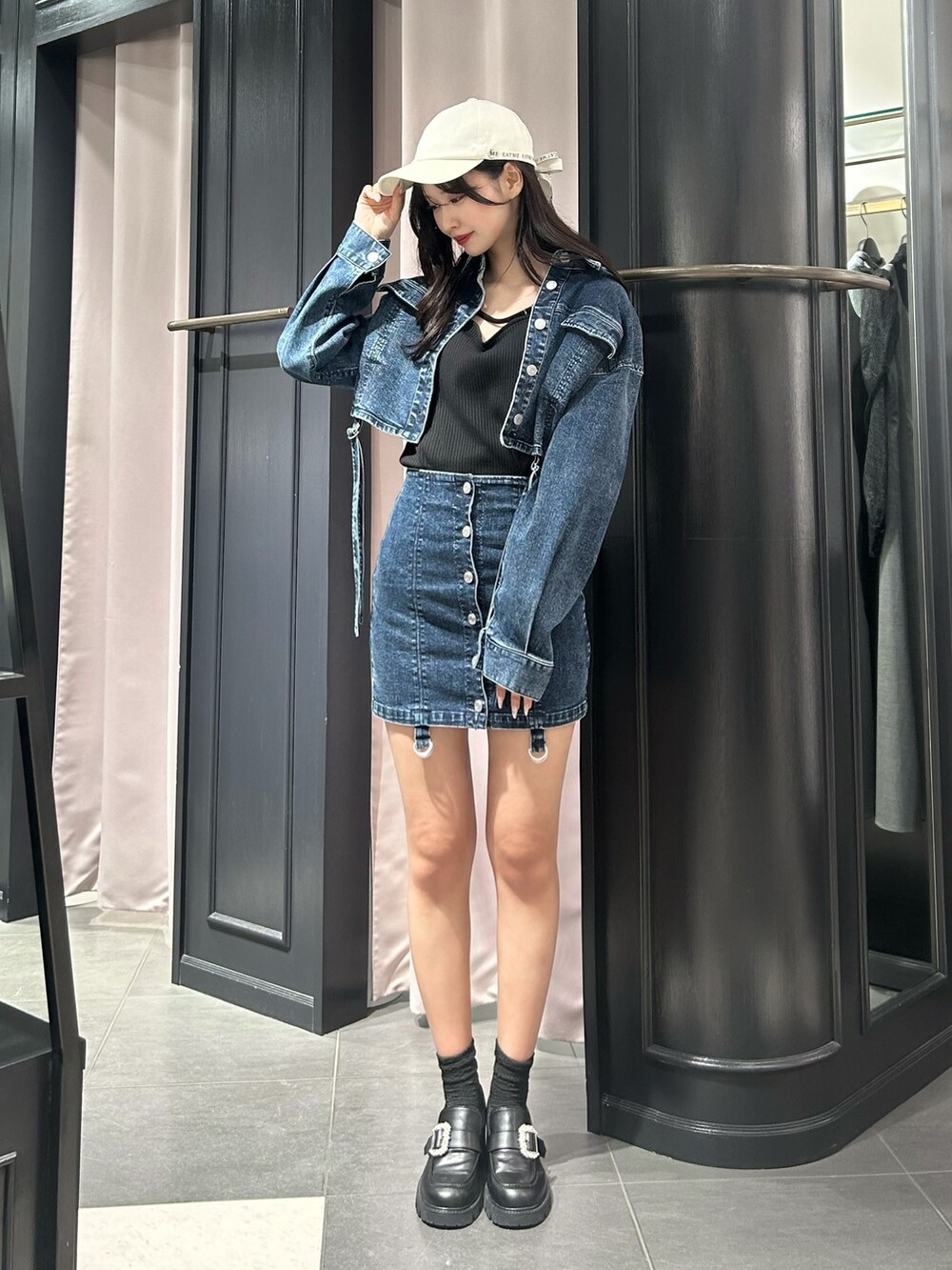 ブルー系のデニムジャケット、ブラック系のTシャツ/カットソー、ブルー系のデニムスカートを着用したレディースの冬コーディネートの3枚目の写真