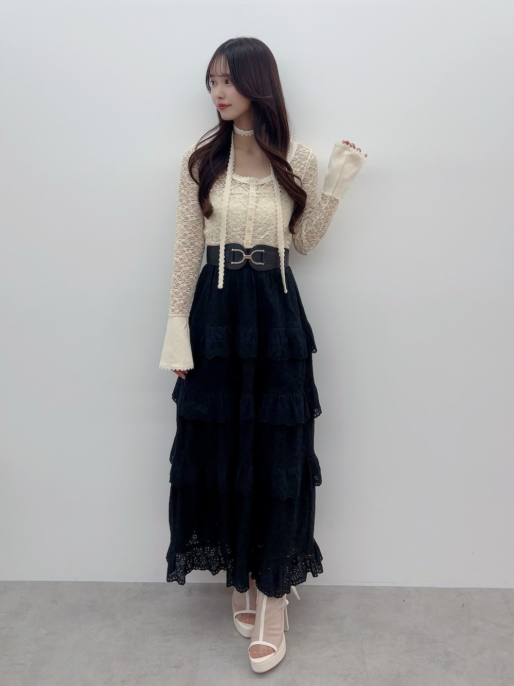 イエロー系のTシャツ/カットソー、ブラック系のスカート、ホワイト系のサンダルを着用したレディースの春コーディネートの2枚目の写真