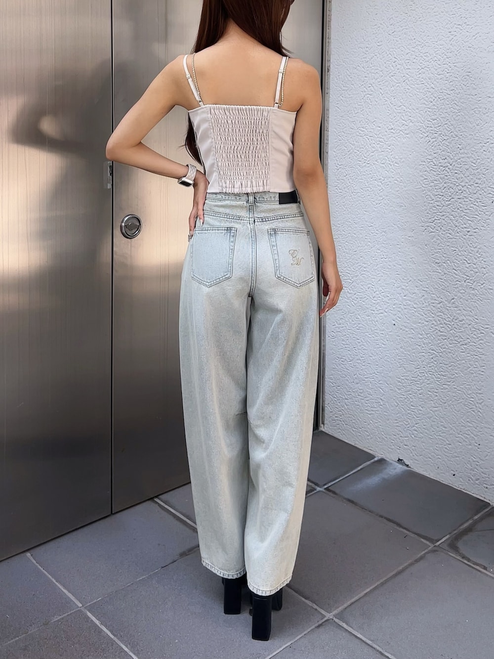 ホワイト系のキャミソール、ブルー系のデニムパンツ、ブラック系のパンプスを着用したレディースの夏コーディネートの3枚目の写真