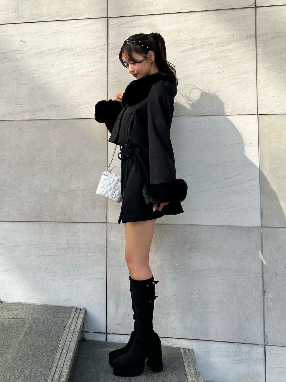 ブラック系のその他アウター、ブラック系のスカート、ブラック系のブーツを着用したレディースの秋コーディネートの3枚目の写真