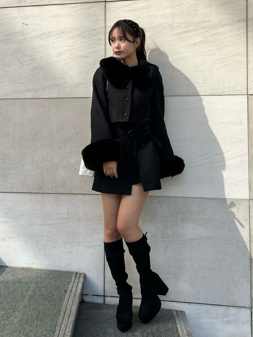 ブラック系のその他アウター、ブラック系のスカート、ブラック系のブーツを着用したレディースの秋コーディネートの2枚目の写真