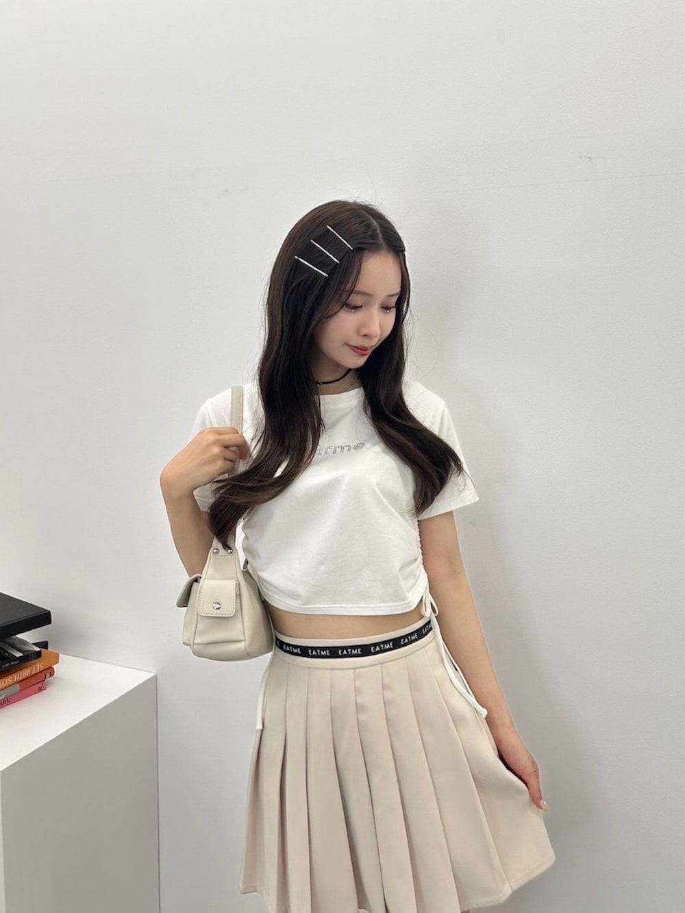 ホワイト系のTシャツ/カットソー、ホワイト系のスカート、ホワイト系のショルダーバッグを着用したレディースの夏コーディネートの2枚目の写真