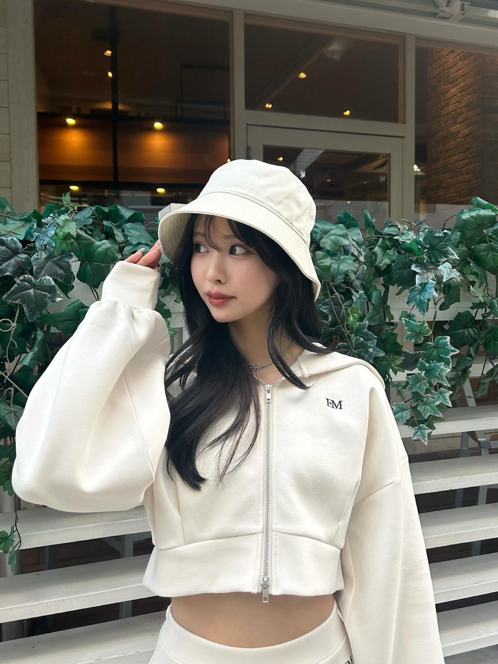 ホワイト系のパーカー、ホワイト系のその他パンツ、ブラック系のパンプスを着用したレディースの冬コーディネートの4枚目の写真