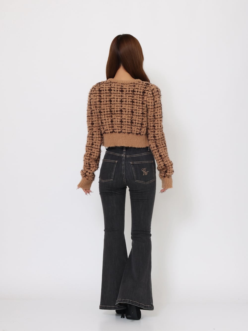 ブラック系のデニムパンツ、ブラウン系のニット/セーター、ブラック系のブーツを着用したレディースの夏コーディネートの4枚目の写真