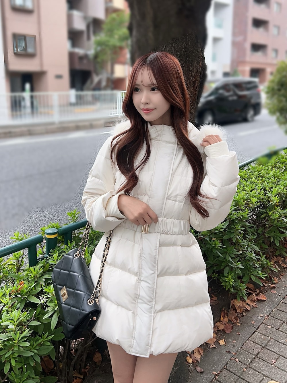 ホワイト系のダウンジャケット/コート、ブラック系のブーツ、ブラック系のハンドバッグを着用したレディースの秋コーディネートの4枚目の写真