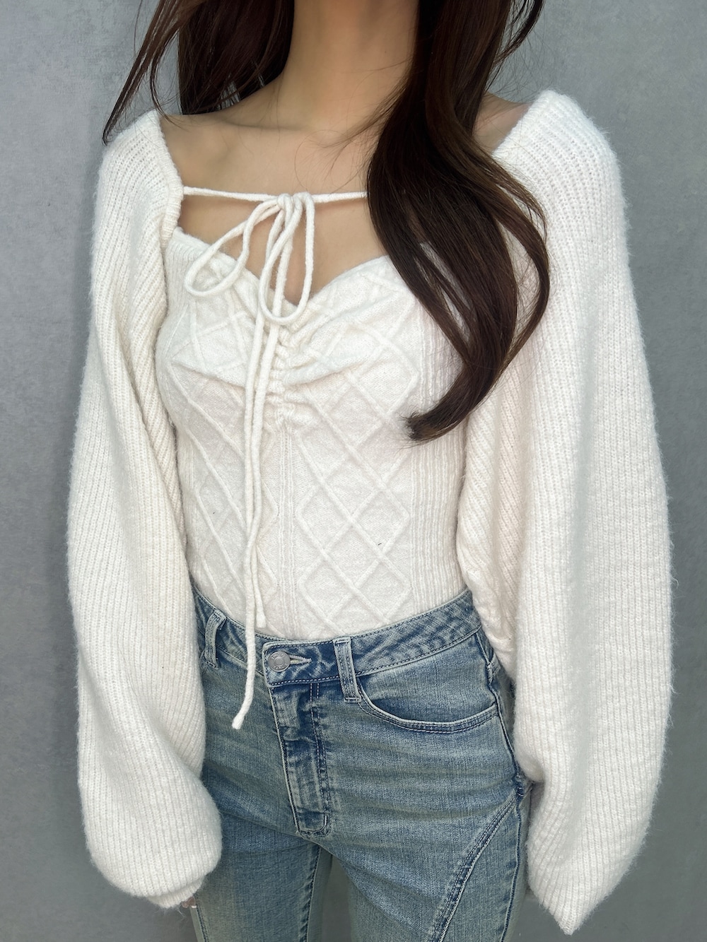 ブルー系のデニムパンツ、ホワイト系のニット/セーター、ブラック系のブーツを着用したレディースの冬コーディネートの6枚目の写真