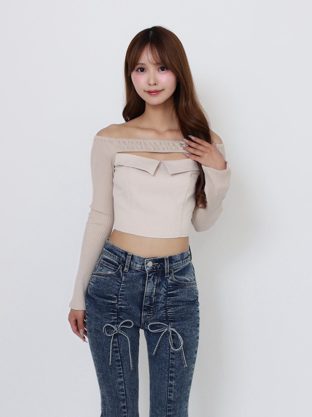 ブラック系のブーツ、ベージュ系のTシャツ/カットソー、ブルー系のデニムパンツを着用したレディースの秋コーディネートの5枚目の写真