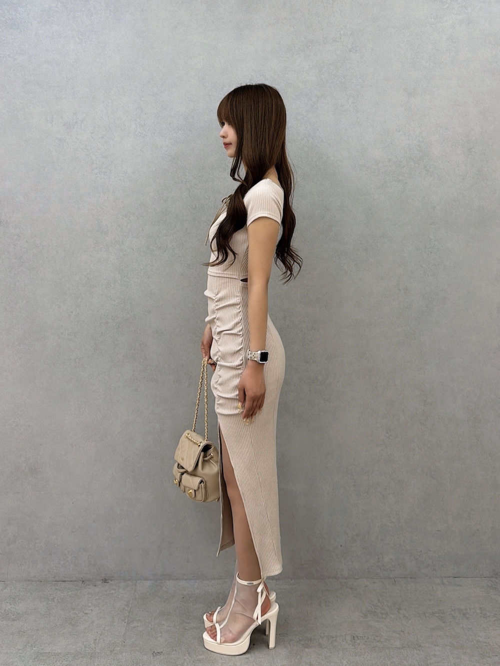 ベージュ系のワンピース、ベージュ系のバックパック/リュック、ホワイト系のサンダルを着用したレディースの春コーディネートの3枚目の写真