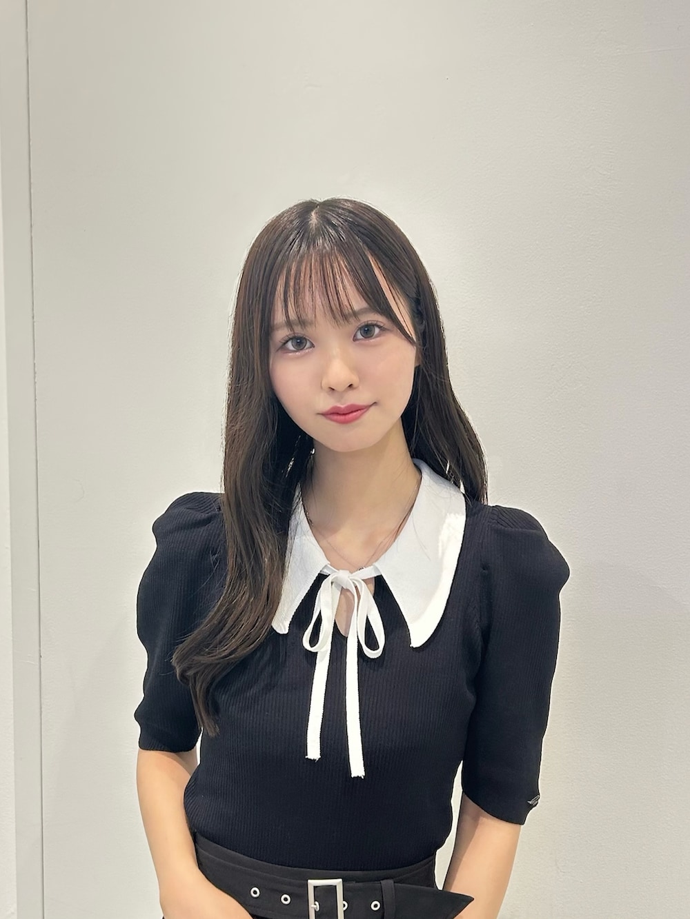 ブラック系のニット/セーター、ブラック系のスカート、ブラック系のサンダルを着用したレディースの夏コーディネートの2枚目の写真