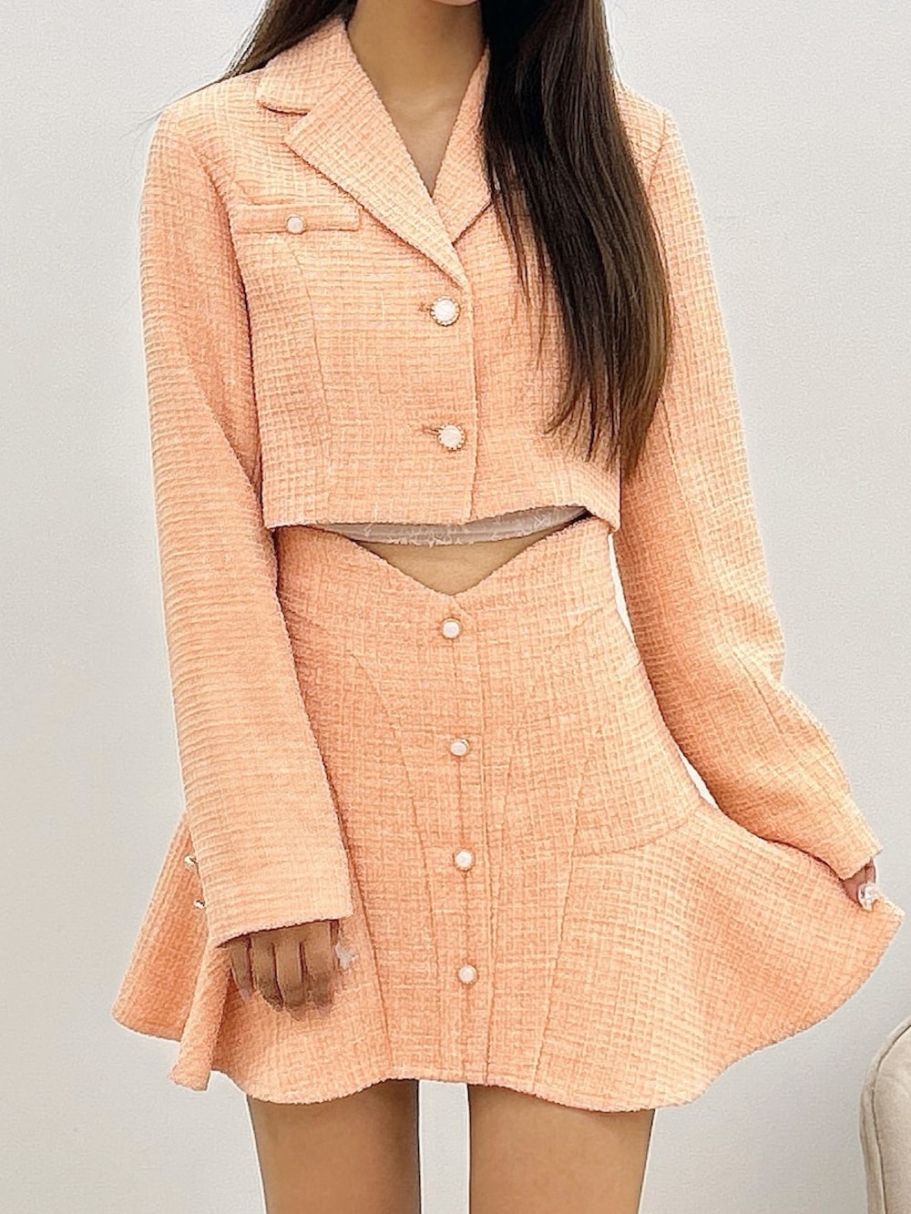 オレンジ系のスカート、オレンジ系のテーラードジャケット、ホワイト系のブーツを着用したレディースの秋コーディネートの5枚目の写真