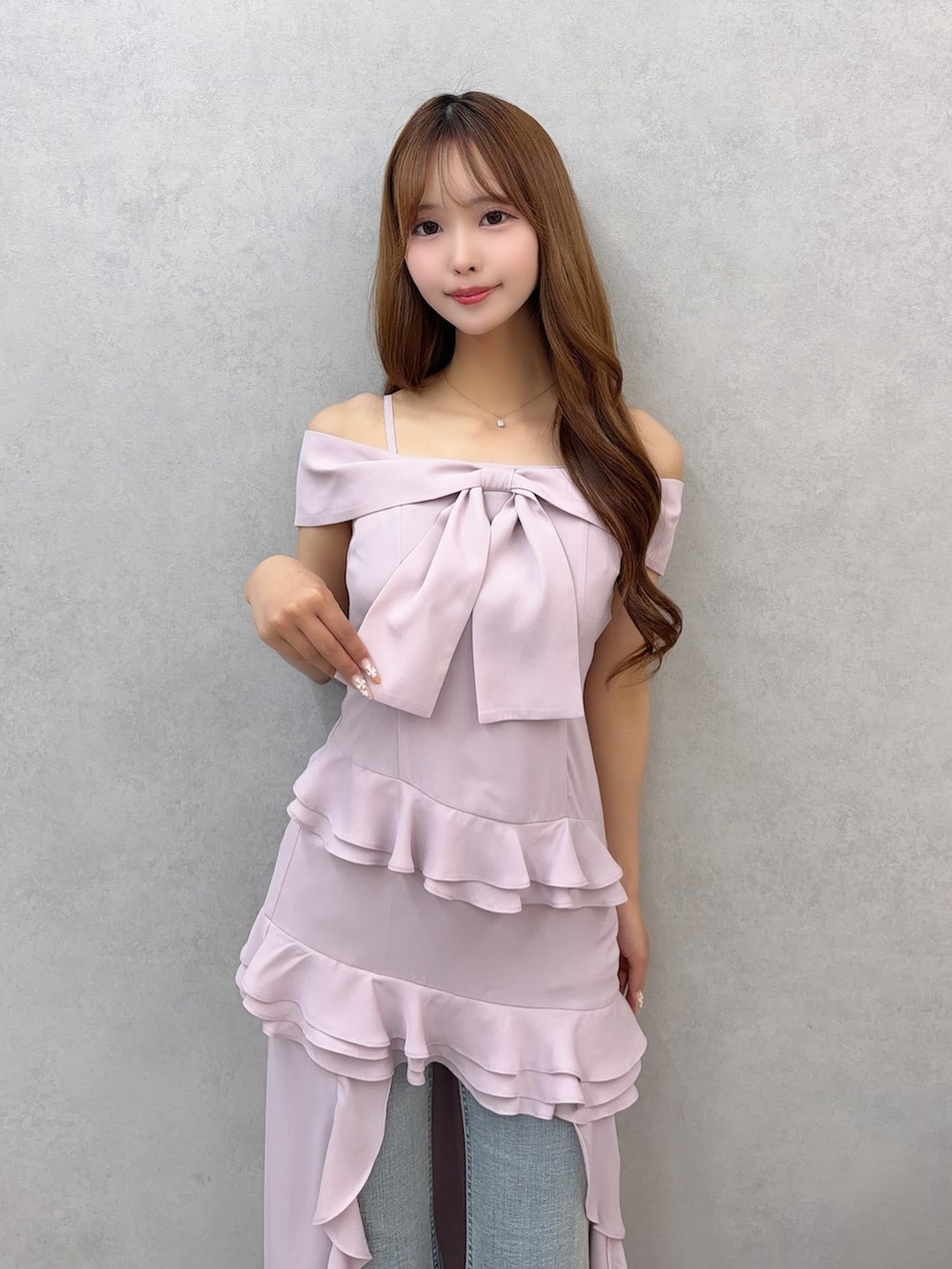 ピンク系のワンピース、ブルー系のデニムパンツを着用したレディースの春コーディネートの6枚目の写真
