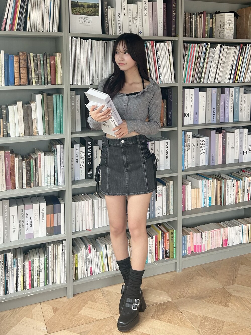グレー系のTシャツ/カットソー、ブラック系のデニムスカート、ブラック系のパンプスを着用したレディースの冬コーディネートの2枚目の写真
