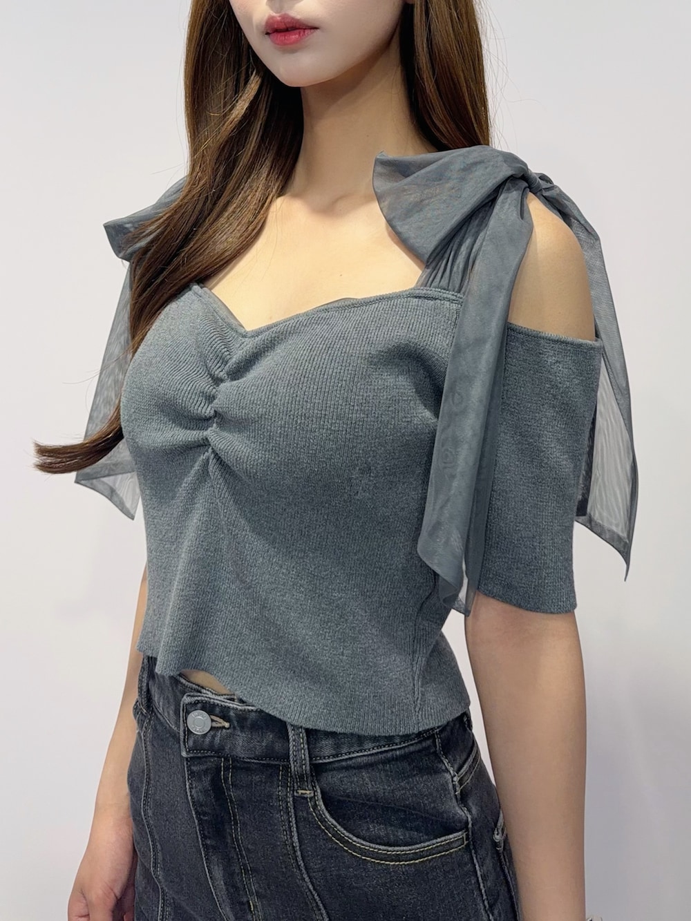 ブラック系のデニムスカート、グレー系のTシャツ/カットソー、ブラック系のサンダルを着用したレディースの春コーディネートの6枚目の写真
