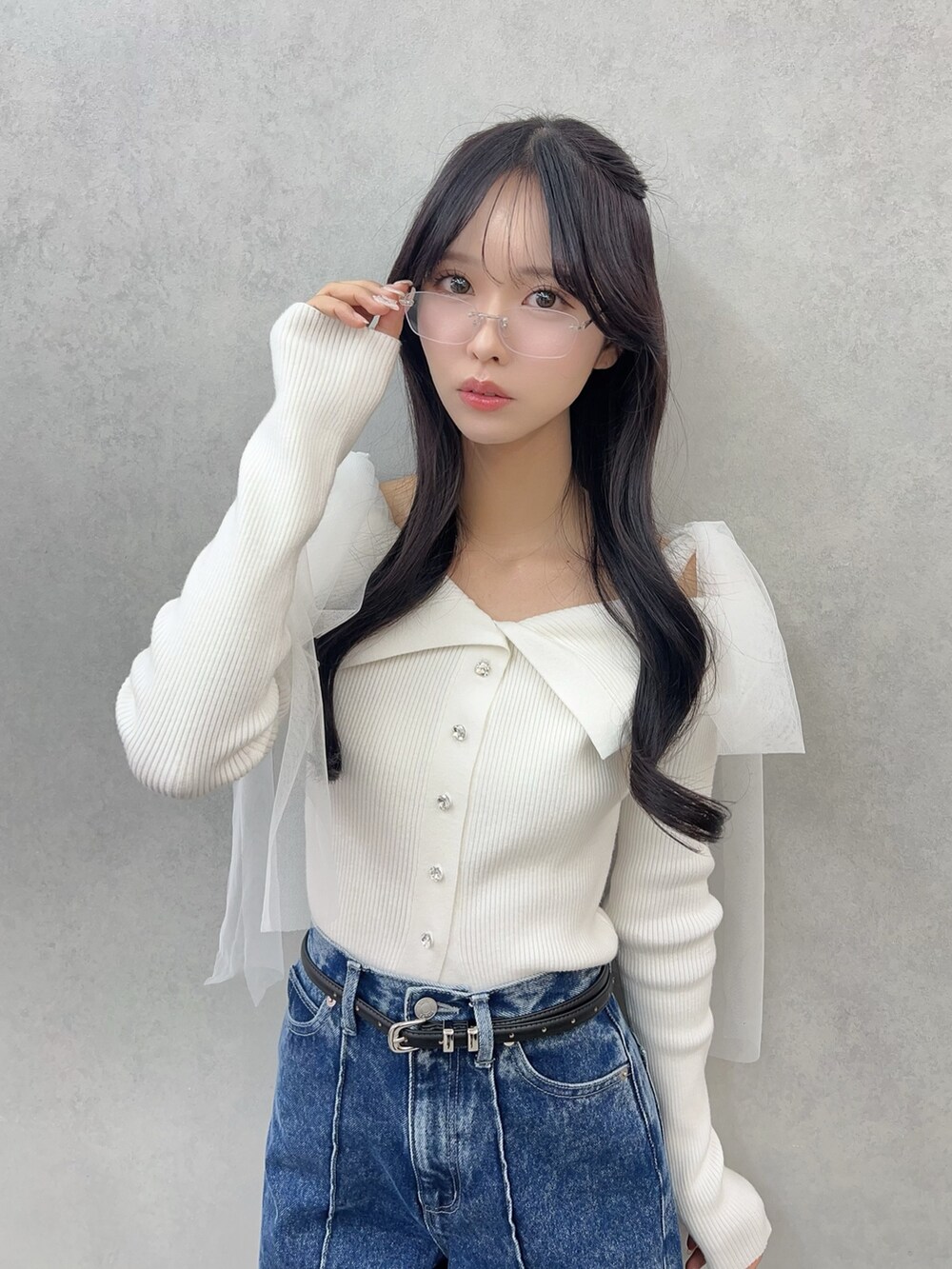 ホワイト系のニット/セーター、ブルー系のデニムパンツ、ブラック系のブーツを着用したレディースの冬コーディネートの4枚目の写真