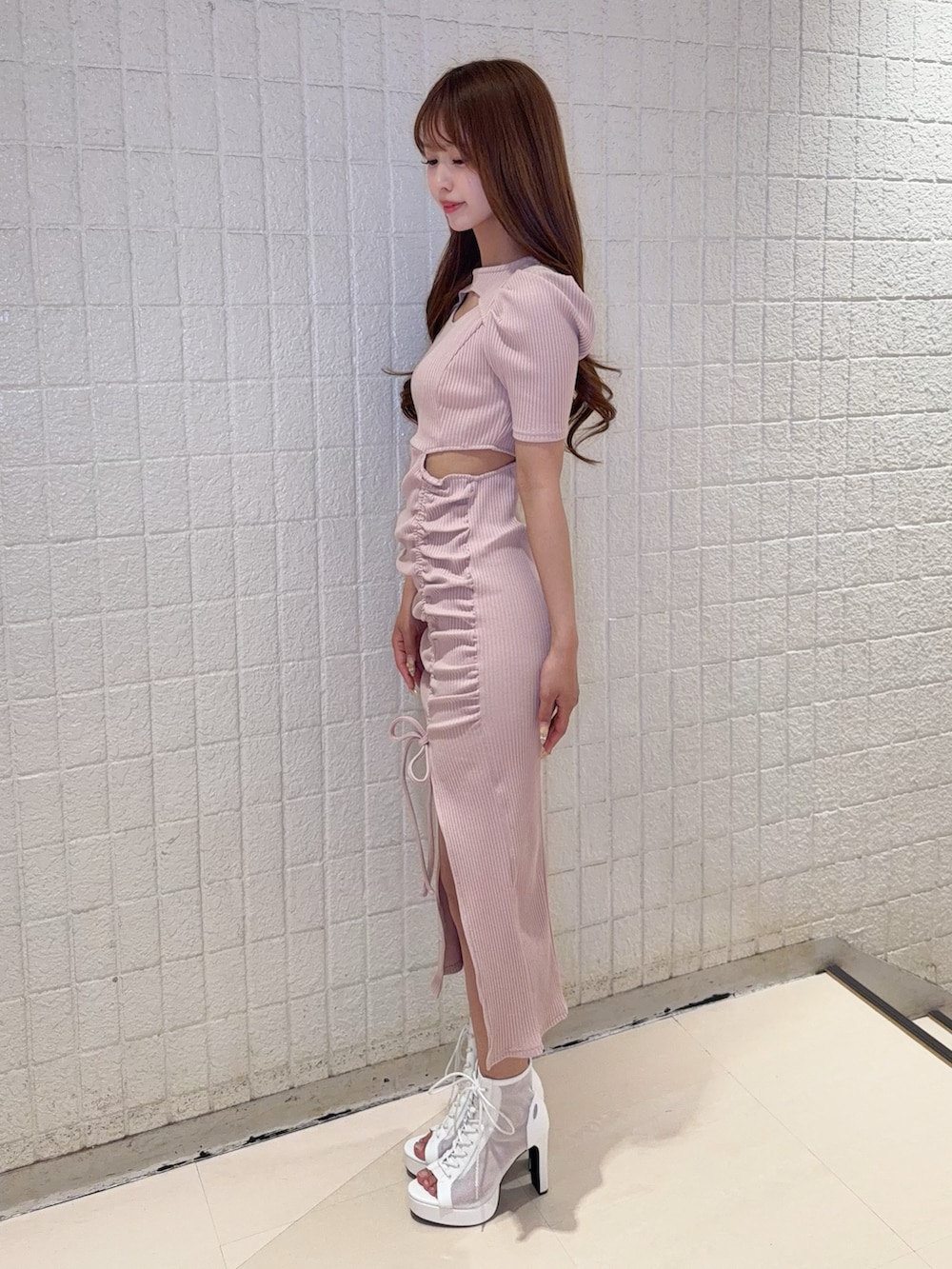 ピンク系のワンピース、ホワイト系のブーツを着用したレディースの春コーディネートの3枚目の写真