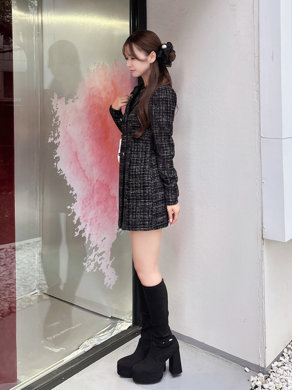 ブラック系のワンピース、ホワイト系のハンドバッグ、ブラック系のブーツを着用したレディースの秋コーディネートの3枚目の写真