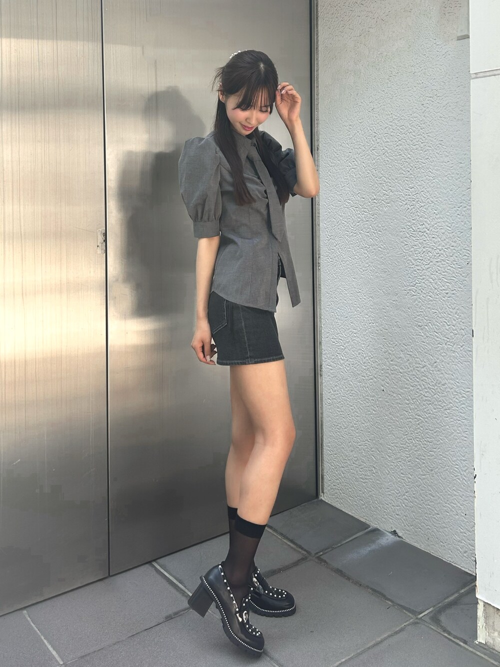 グレー系のシャツ/ブラウス、ブラック系のデニムスカート、ブラック系のローファーを着用したレディースの秋コーディネートの4枚目の写真