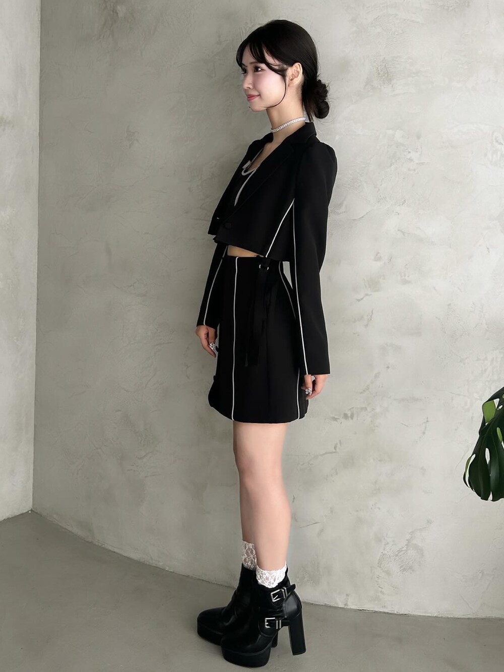 ブラック系のテーラードジャケット、ブラック系のキャミソール、ブラック系のスカートを着用したレディースの秋コーディネートの4枚目の写真