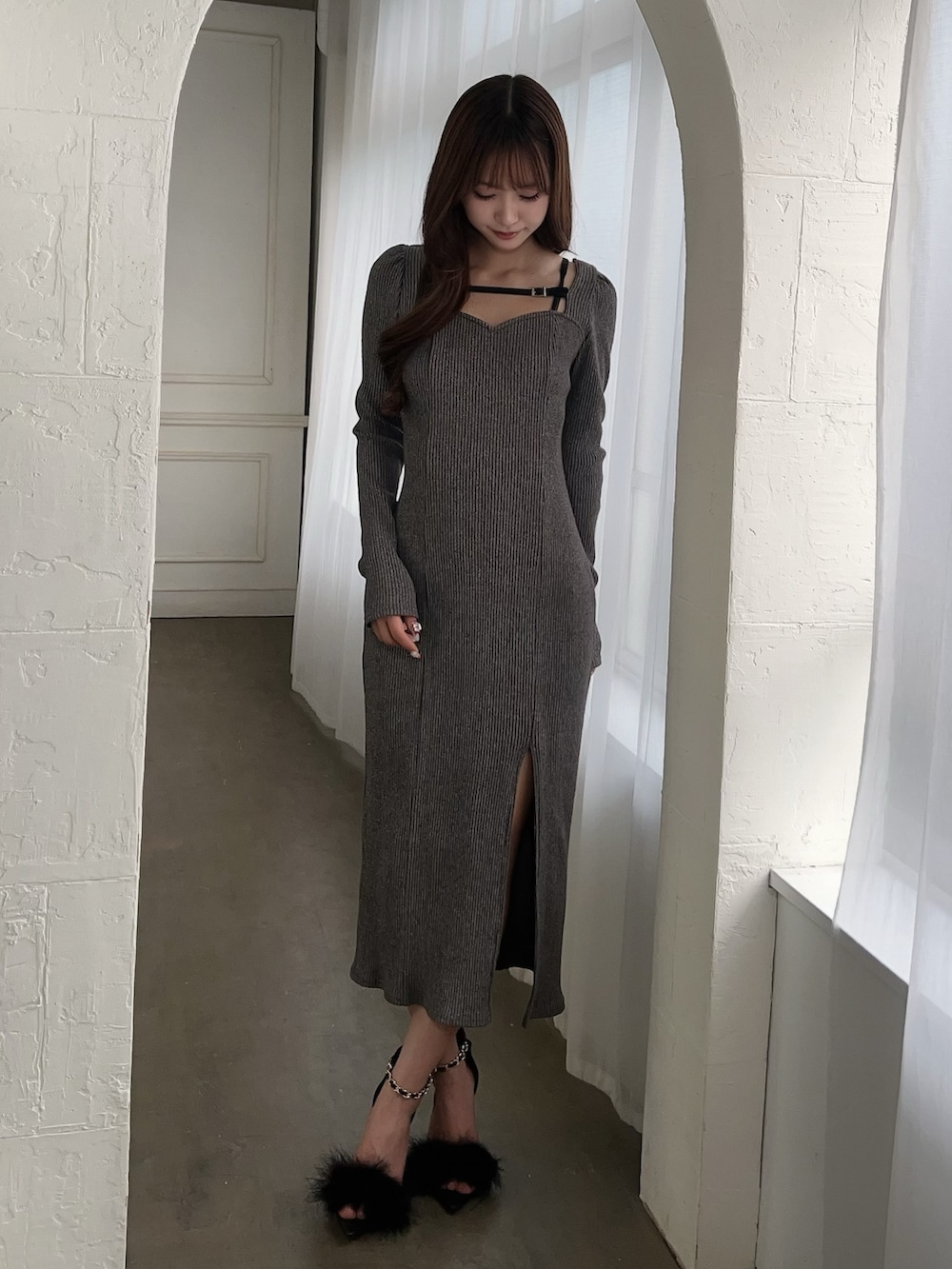 グレー系のワンピース、ブラック系のサンダルを着用したレディースの冬コーディネートの2枚目の写真