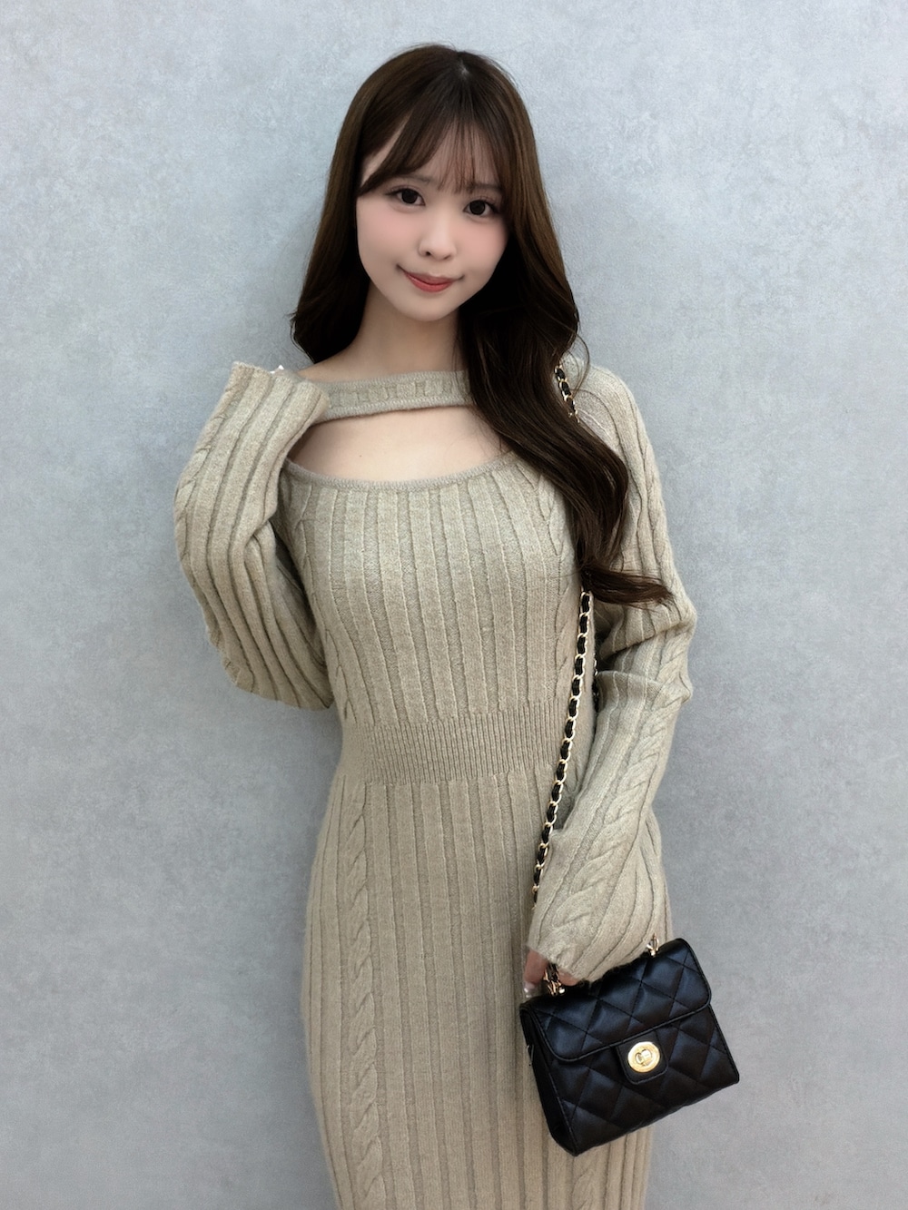 ベージュ系のワンピース、ブラック系のハンドバッグ、ブラック系のサンダルを着用したレディースの冬コーディネートの5枚目の写真