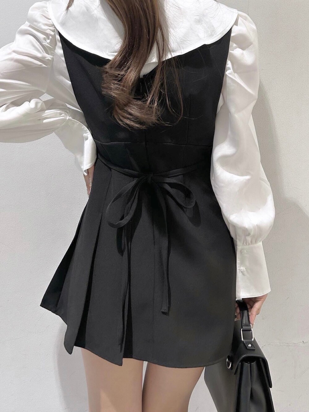 ブラック系のローファー、ホワイト系のシャツ/ブラウス、ブラック系のジャンパースカートを着用したレディースの秋コーディネートの5枚目の写真