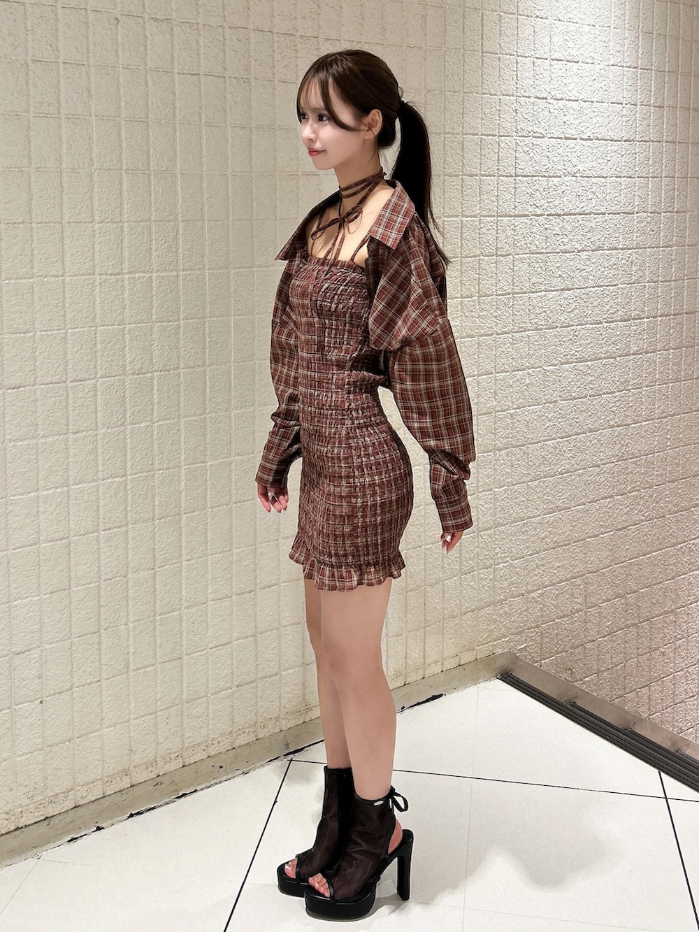 レッド系のワンピース、ブラック系のサンダルを着用したレディースの秋コーディネートの2枚目の写真