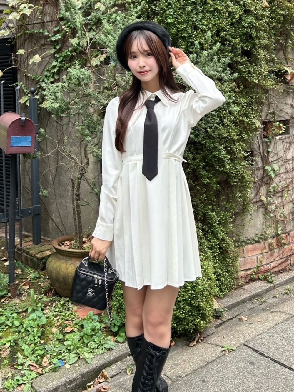 ホワイト系のワンピース、ブラック系のハンドバッグ、ブラック系のブーツを着用したレディースの秋コーディネートの5枚目の写真