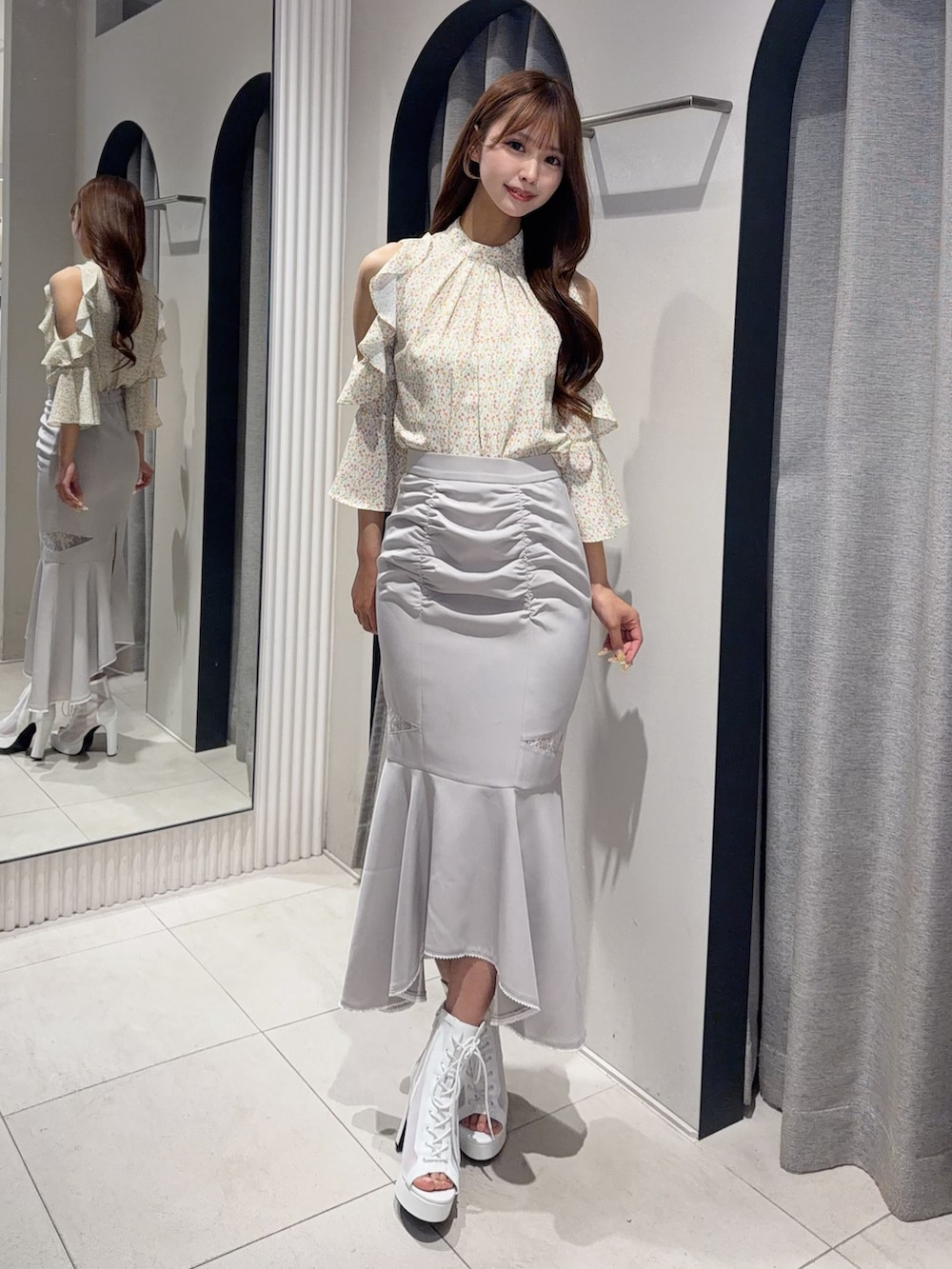 グレー系のスカート、イエロー系のシャツ/ブラウス、ホワイト系のブーツを着用したレディースの春コーディネートの2枚目の写真