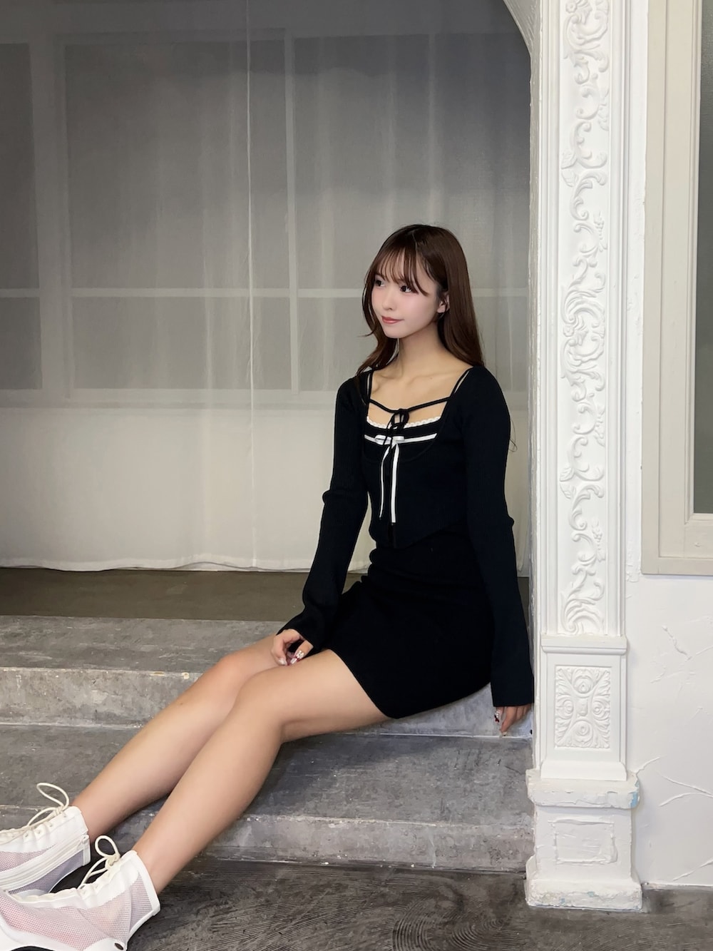 ブラック系のワンピース、ホワイト系のブーツを着用したレディースの冬コーディネートの6枚目の写真