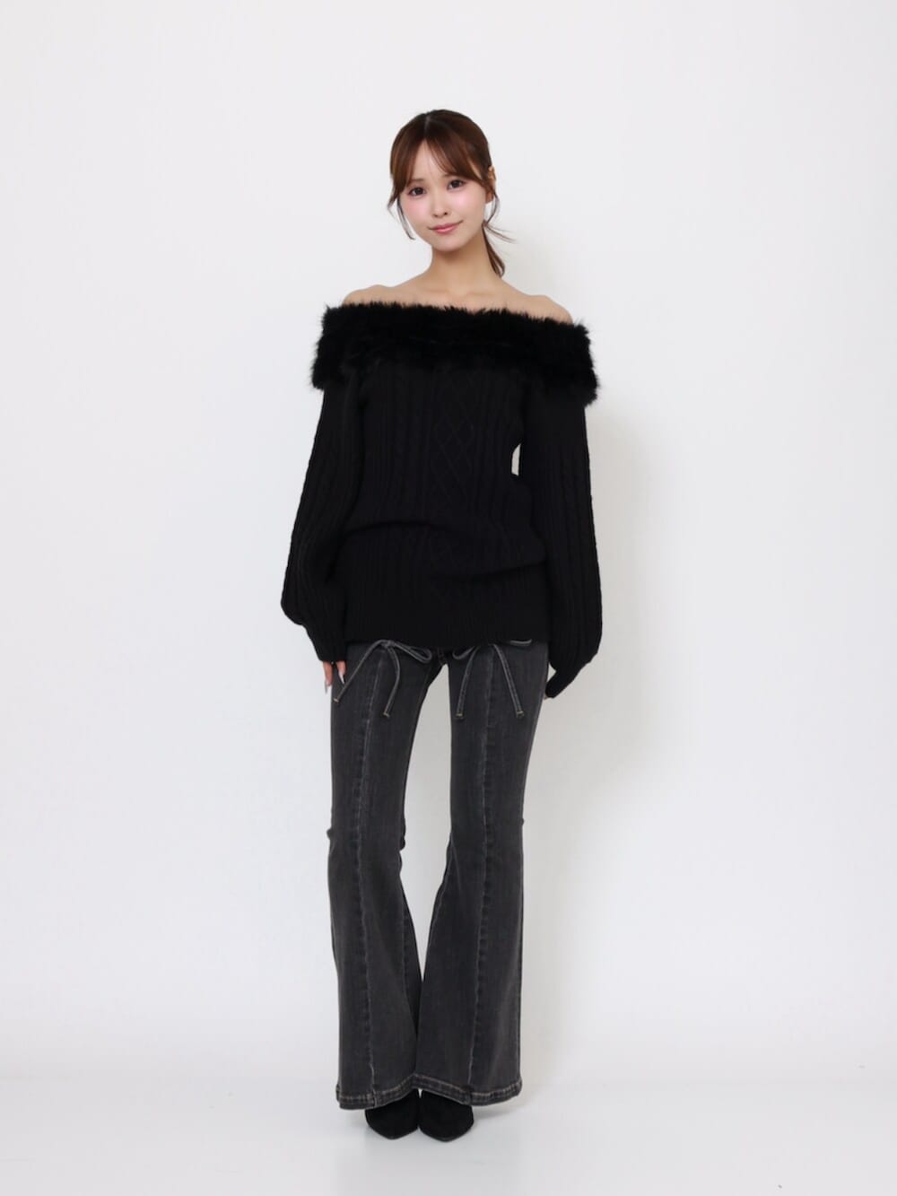ブラック系のデニムパンツ、ブラック系のブーツ、ブラック系のニット/セーターを着用したレディースの秋コーディネートの2枚目の写真