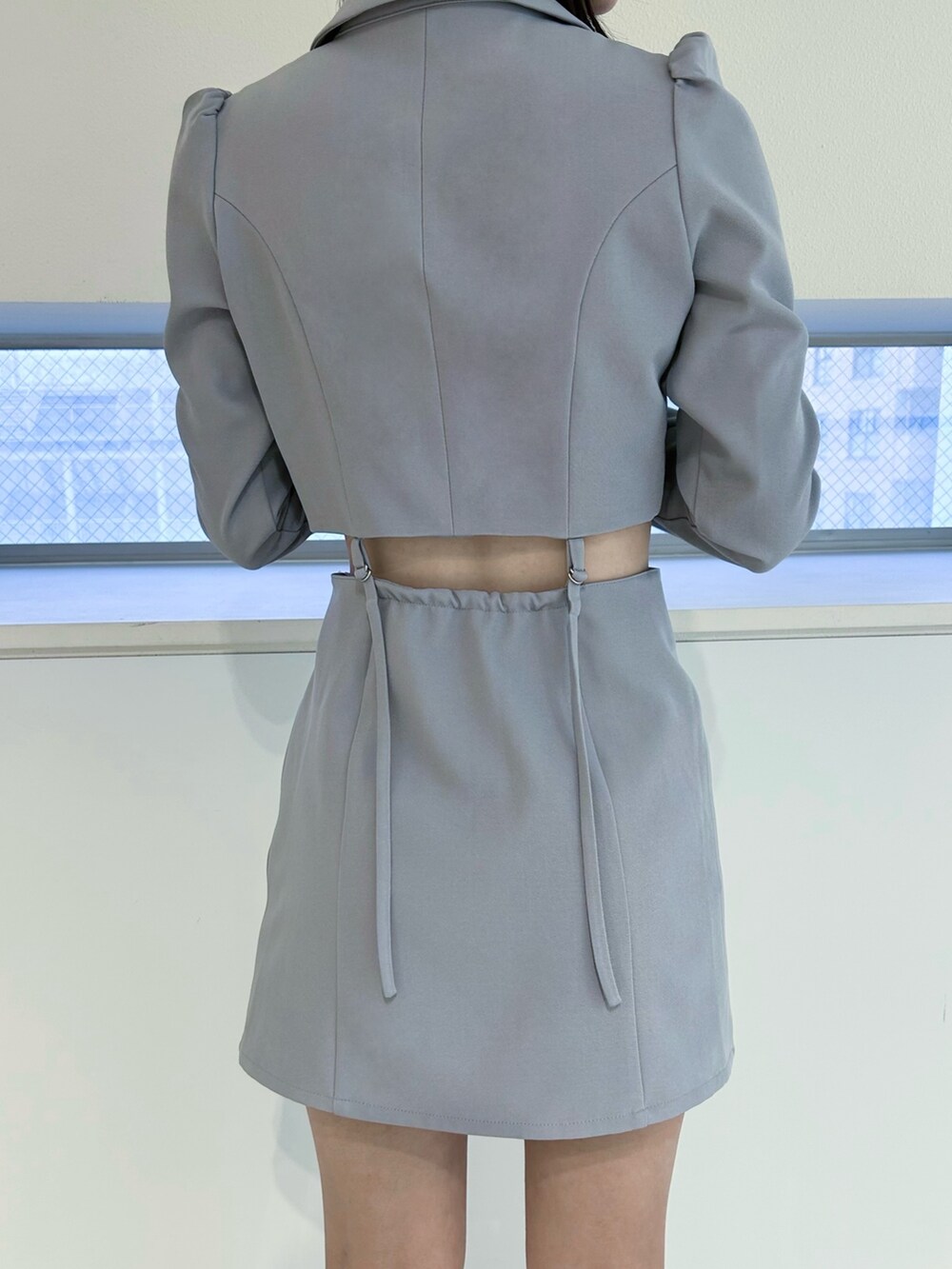 ブルー系のワンピース、ブラック系のパンプス、シルバー系のネックレスを着用したレディースの冬コーディネートの4枚目の写真