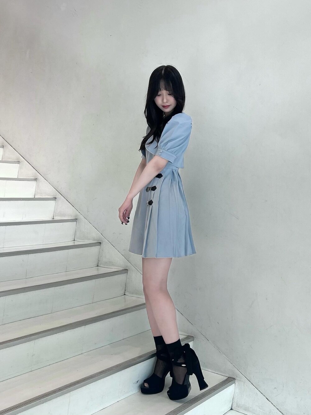 ブルー系のワンピース、ブラック系のショルダーバッグ、ブラック系のサンダルを着用したレディースの春コーディネートの2枚目の写真