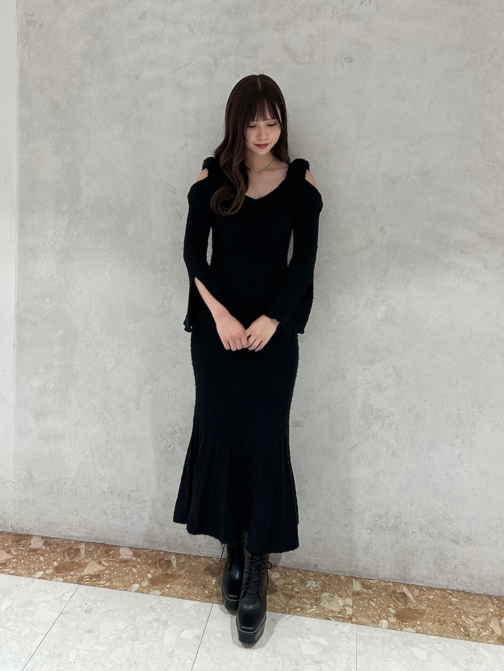 ブラック系のワンピース、ブラック系のブーツ、シルバー系のピアス（両耳用）を着用したレディースの秋コーディネートの2枚目の写真