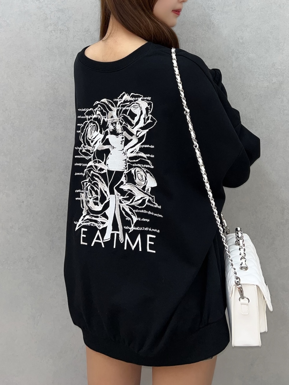 ブラック系のスウェット、ブルー系のデニムスカート、ホワイト系のショルダーバッグを着用したレディースの秋コーディネートの6枚目の写真