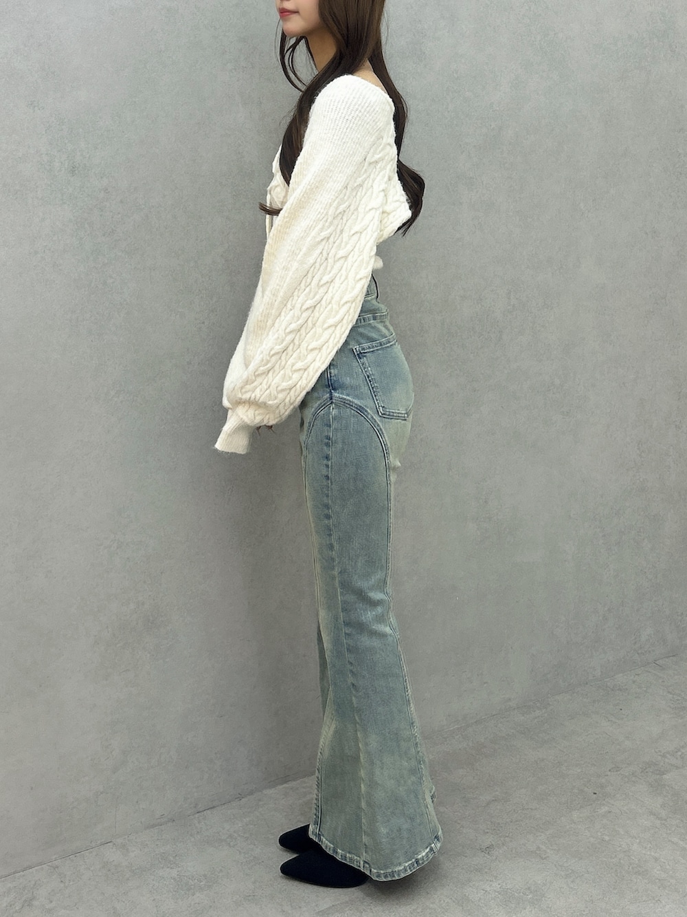 ブルー系のデニムパンツ、ホワイト系のニット/セーター、ブラック系のブーツを着用したレディースの冬コーディネートの3枚目の写真