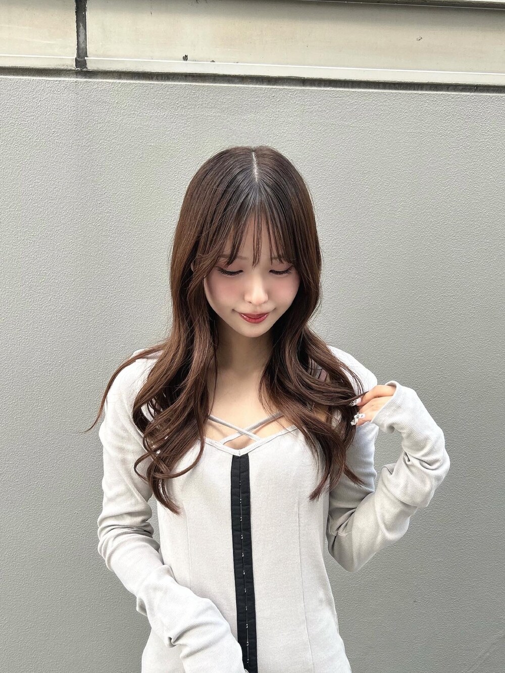 グレー系のワンピース、ブラック系のショルダーバッグ、ブラック系のブーツを着用したレディースの秋コーディネートの4枚目の写真