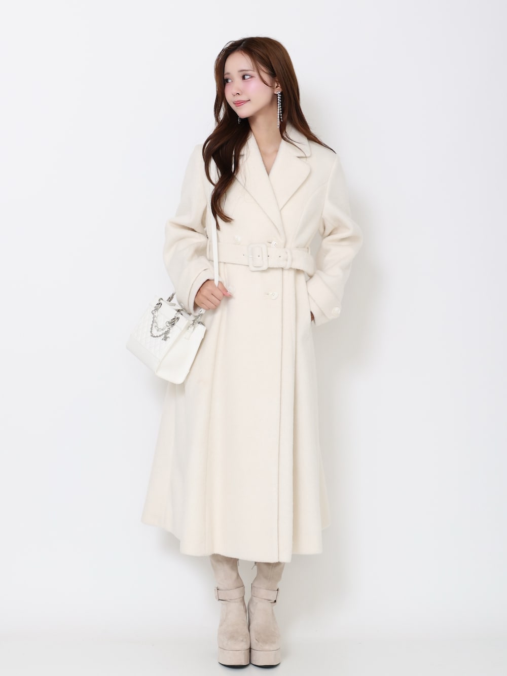 ホワイト系のその他アウター、ホワイト系のブーツ、ホワイト系のハンドバッグを着用したレディースの冬コーディネートの2枚目の写真