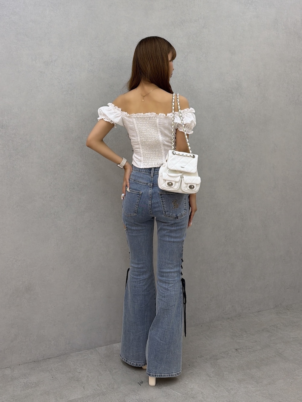 ブルー系のデニムパンツ、ホワイト系のシャツ/ブラウス、ホワイト系のバックパック/リュックを着用したレディースの夏コーディネートの4枚目の写真