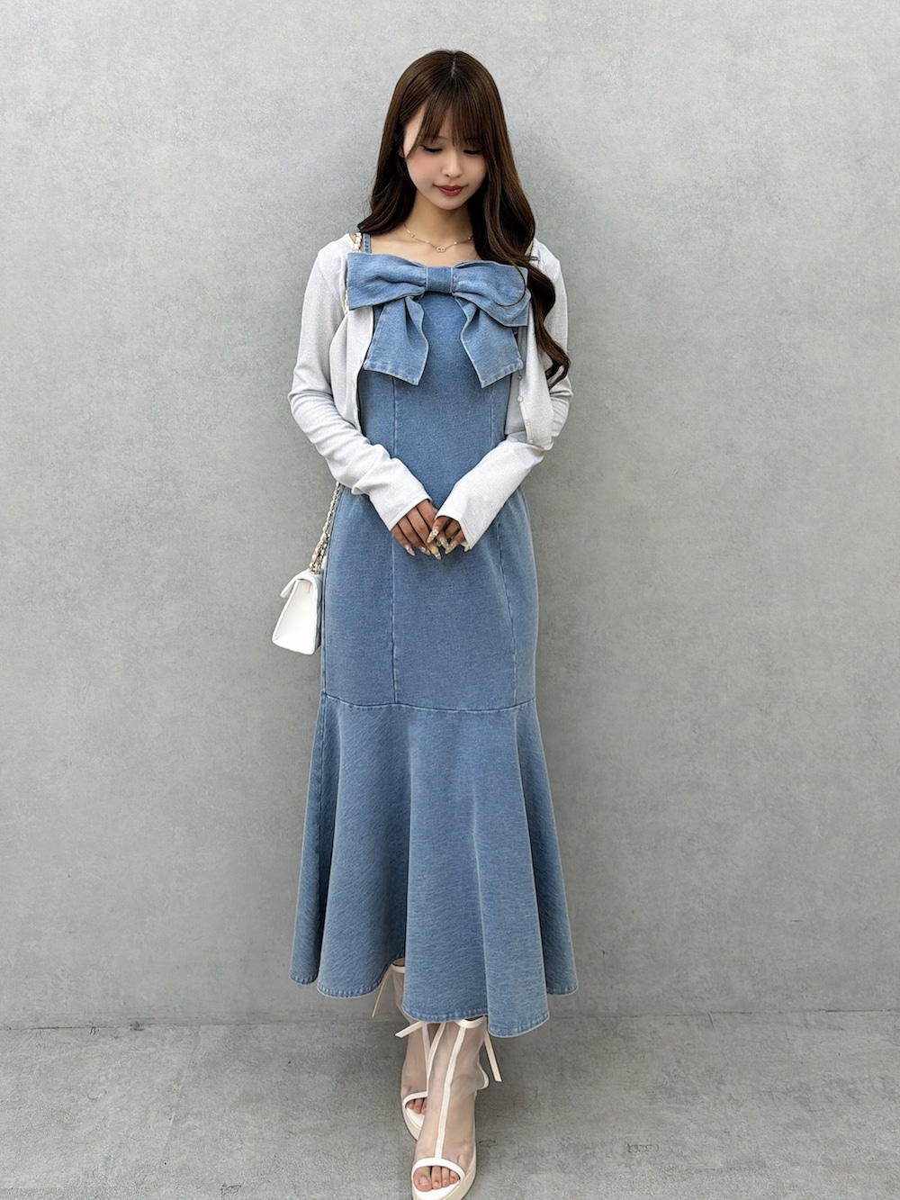 ブルー系のワンピース、グレー系のカーディガン/ボレロ、ホワイト系のサンダルを着用したレディースの春コーディネートの2枚目の写真