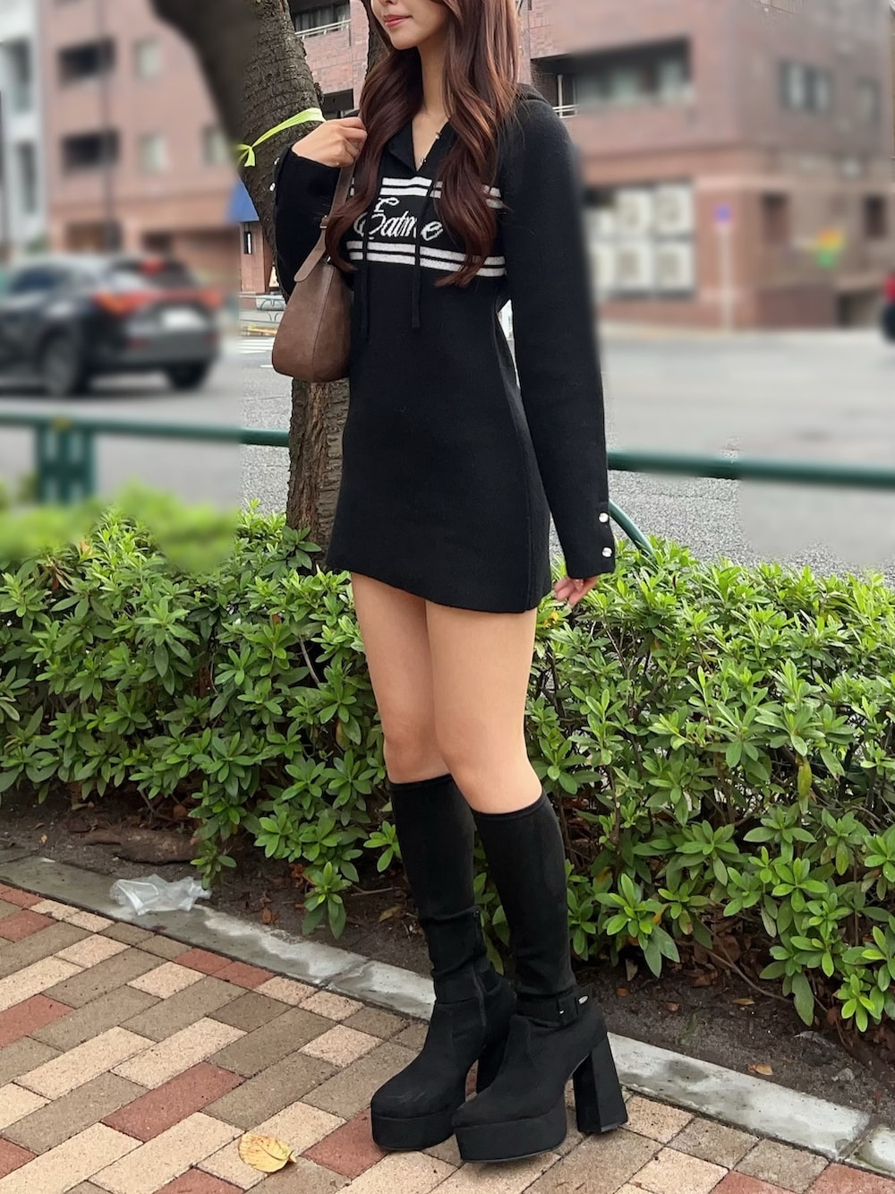 ブラック系のブーツ、ブラック系のワンピース、ブラウン系のショルダーバッグを着用したレディースの秋コーディネートの3枚目の写真