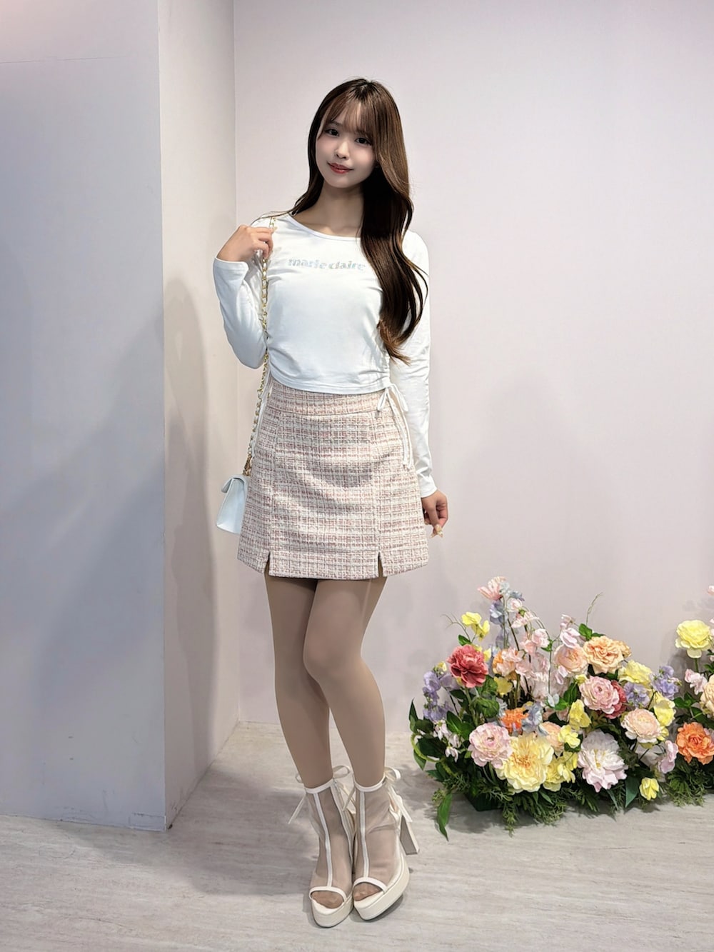 ホワイト系のTシャツ/カットソー、ピンク系のスカート、ホワイト系のサンダルを着用したレディースの冬コーディネートの2枚目の写真