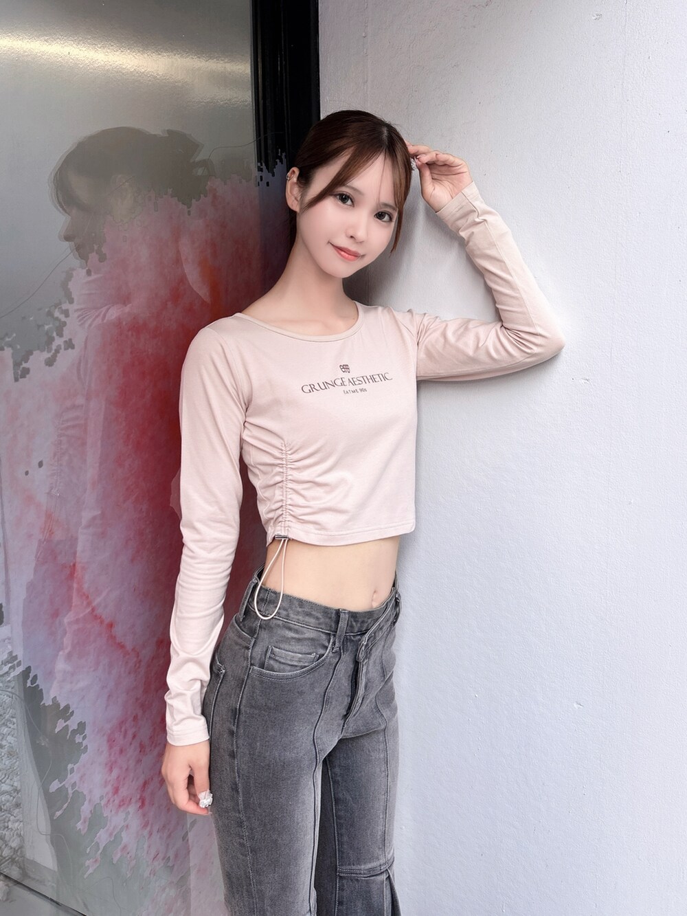ブラック系のデニムパンツ、ピンク系のTシャツ/カットソー、ホワイト系のサンダルを着用したレディースの秋コーディネートの5枚目の写真